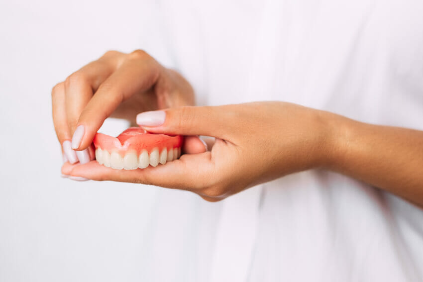 Woman holding new dentures