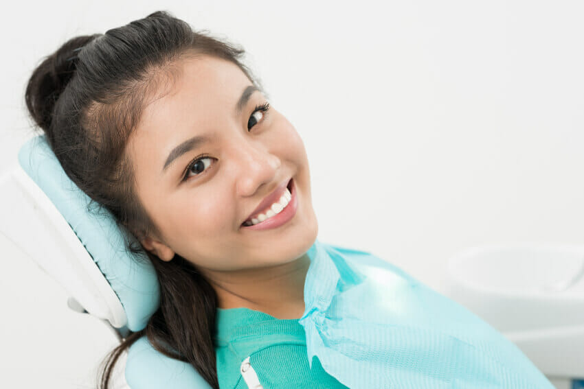 Woman sitting in dental chair getting ready to receive a frenectomy