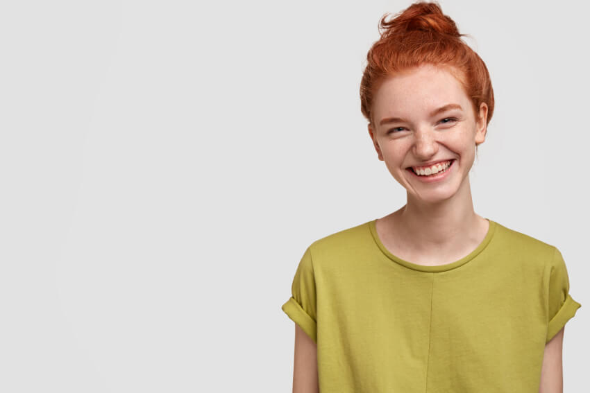 Woman with red hair and green shirt smiling