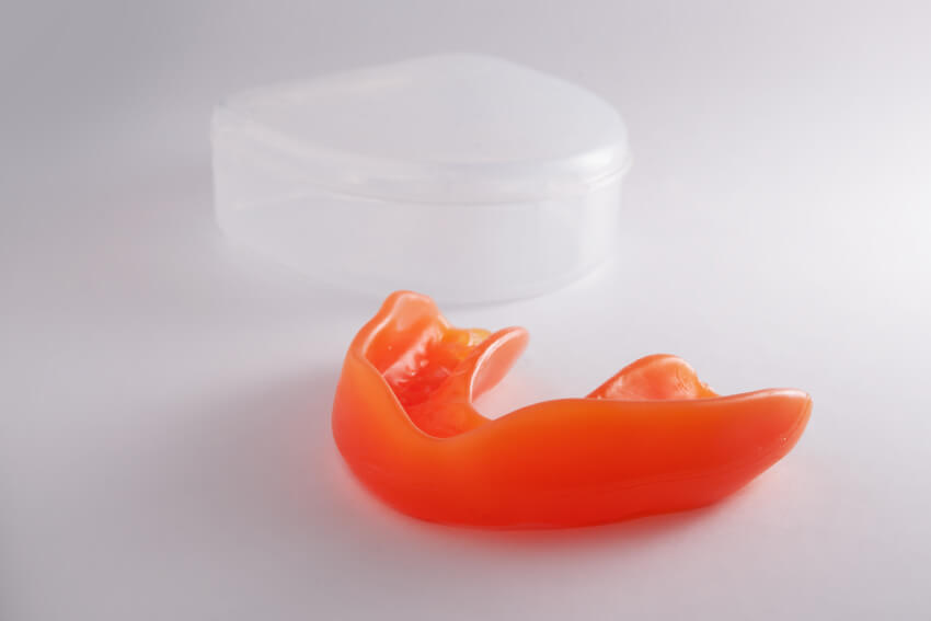 Orange mouth guard laying on table