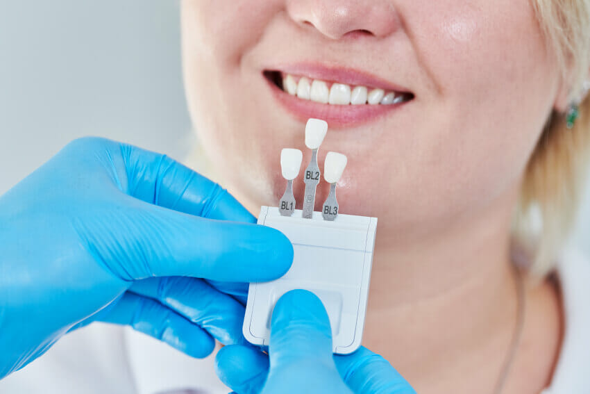 Woman smiling in dental office receiving restorative dentist services