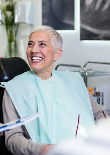 Woman laughing while sitting in dental chair